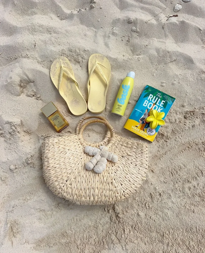 Beach bag and coconut on golden sand at Vung Bau