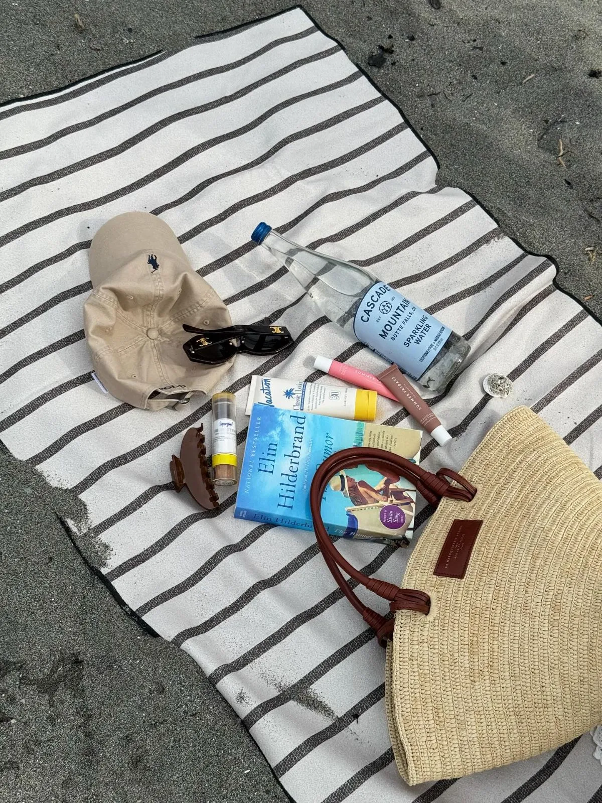 Hiking boots and a thermos on the pebbles of a Lofoten beach