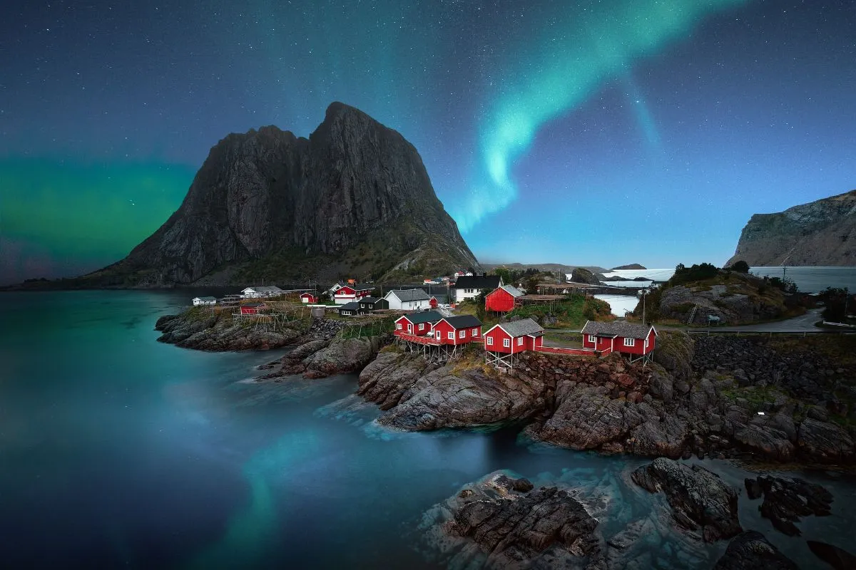 Green aurora borealis reflecting in tidal pools on Gimsøya island in Lofoten