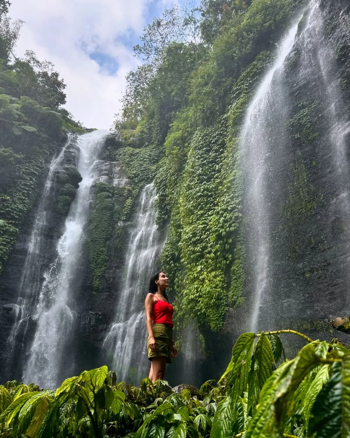 The majestic twin cascades of Sekumpul Waterfall surrounded by dense tropical jungle in North Bali during a sunny morning.