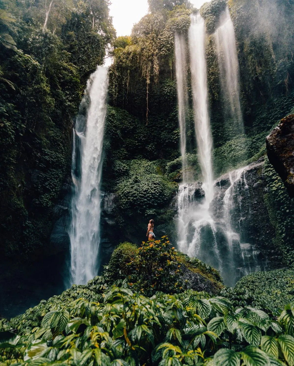 Towering Sekumpul twin waterfall surrounded by lush green jungle in North Bali