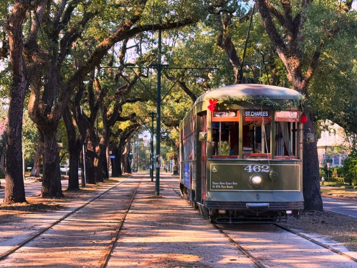 Historic green streetcar rolling down St Charles Avenue
