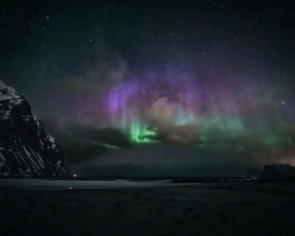 Storsandnes beach wet sand reflecting green northern lights at night