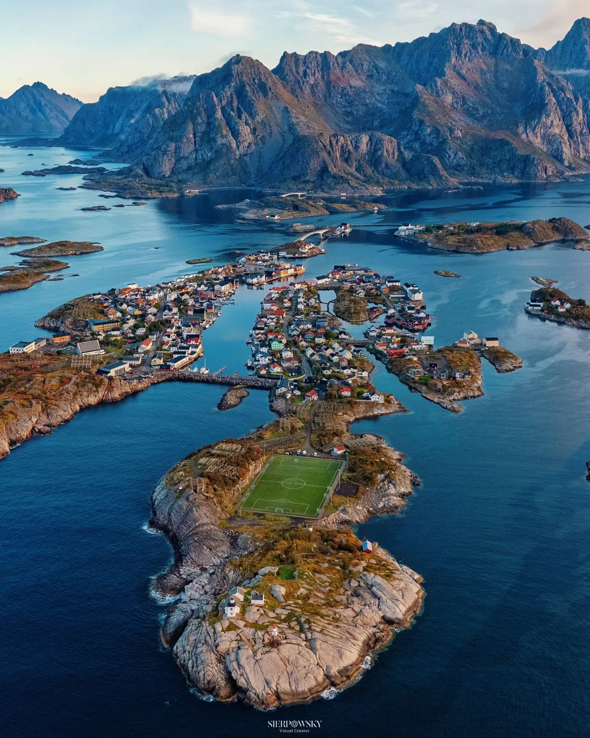 A scenic view of red fisherman cabins and mountains in Svolvær harbor, Lofoten Islands, Norway.