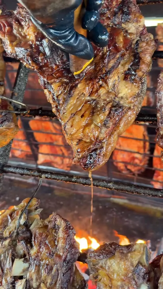 Authentic Argentine asado cooking over a wood fire at an estancia