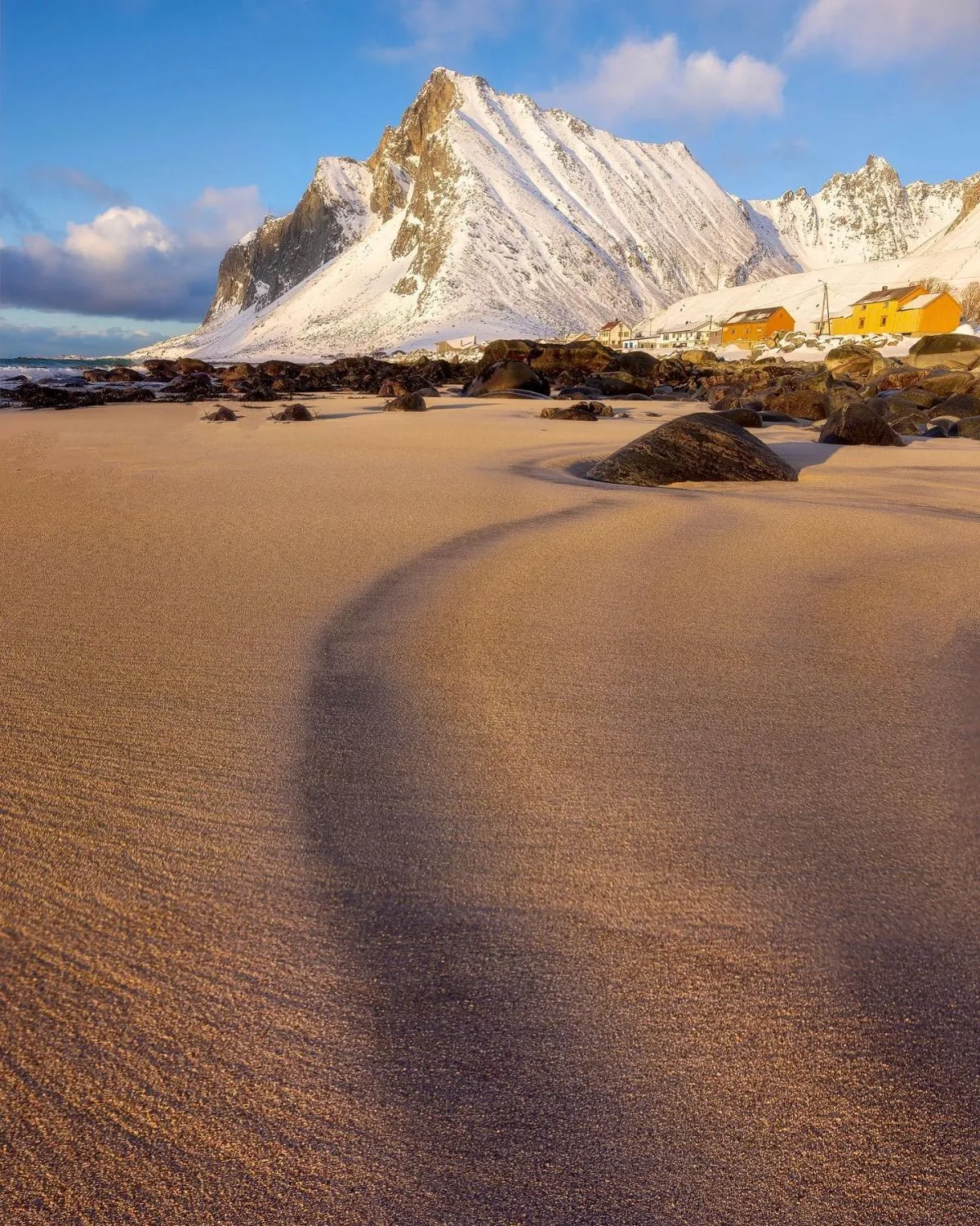 Rugged coastline and glassy waters of Vikten Beach in the Lofoten Islands