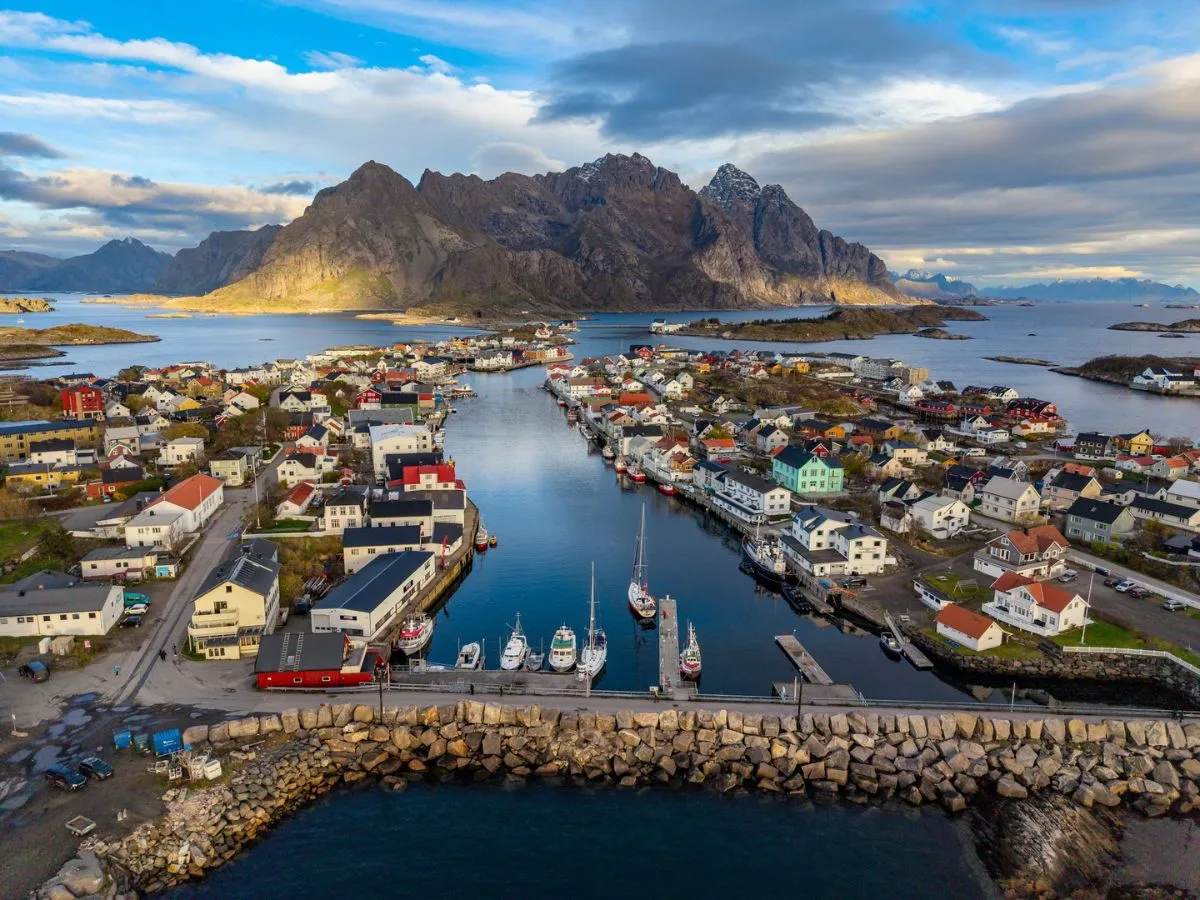 Tourist walking path along the Henningsvaer harbor with fishing boats
