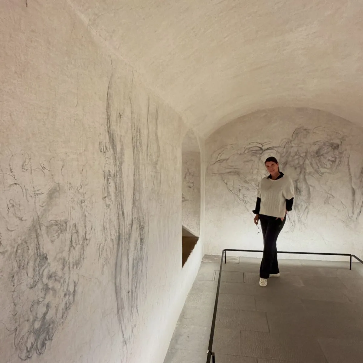 Ancient charcoal wall drawings illuminated by soft lighting inside Michelangelo