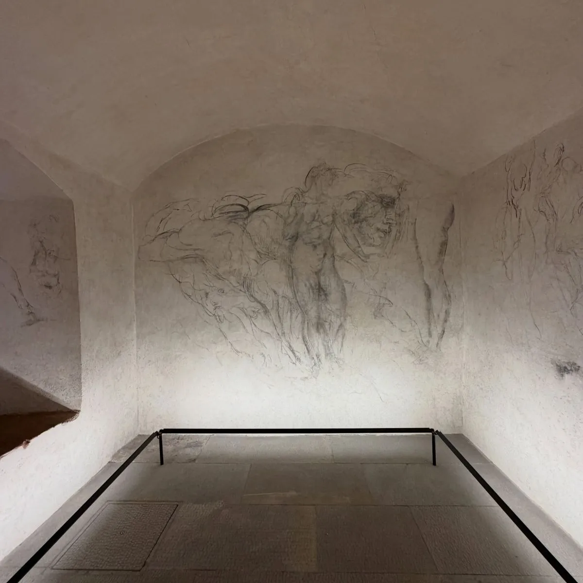Close-up of ancient plaster and brick walls inside the dimly lit secret room of Michelangelo in Florence, Italy.